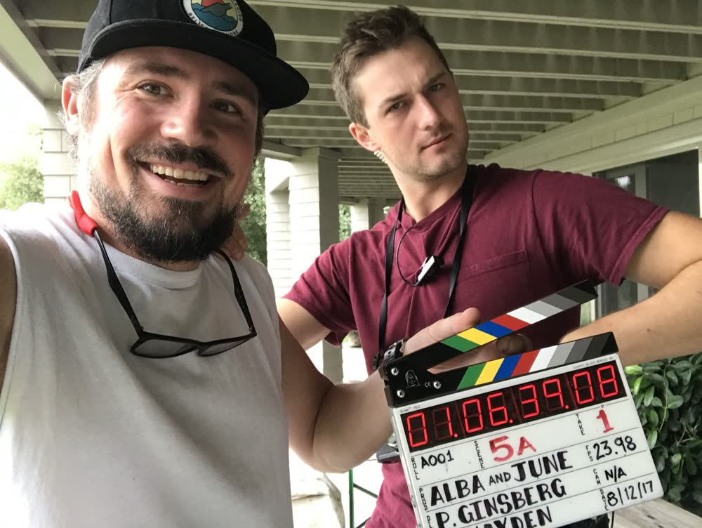 Two crew members with a slate on a porch set in 2017