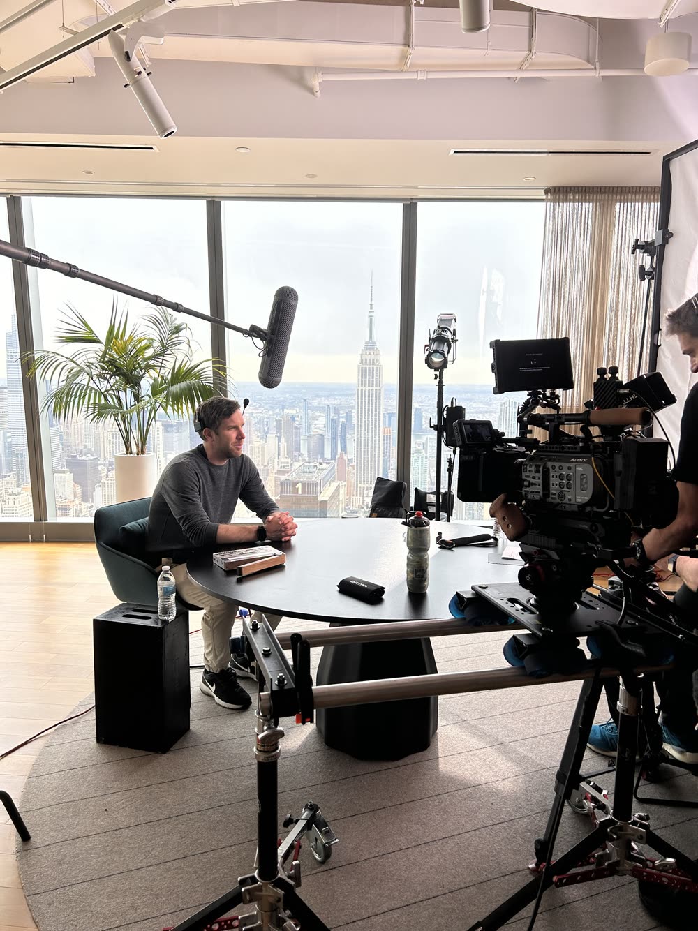 Interview set in a high-rise with a skyline view, boom mic and cinema camera on a dolly